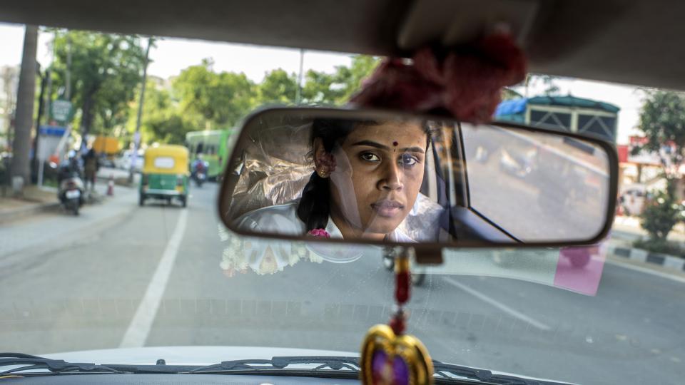 Ashwini tittar i backspegeln när hon kör Uber-taxi.