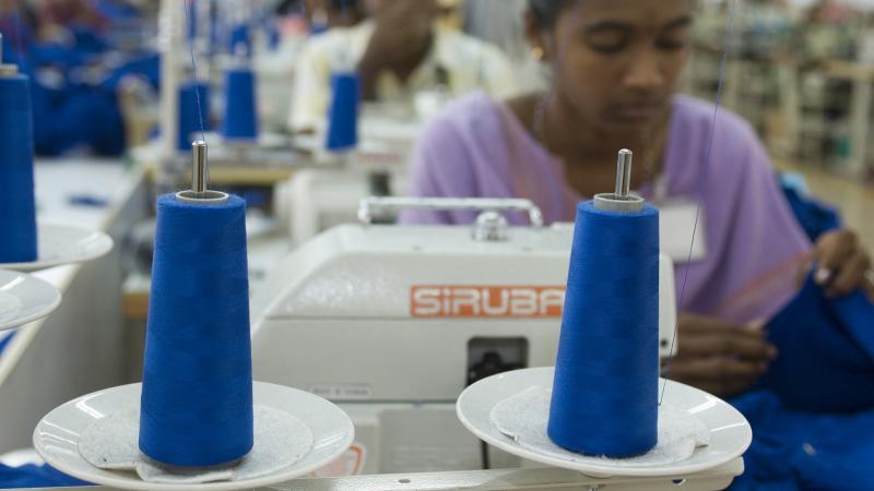 En kvinna vid en symaskin vid en textilfabrik i Indien