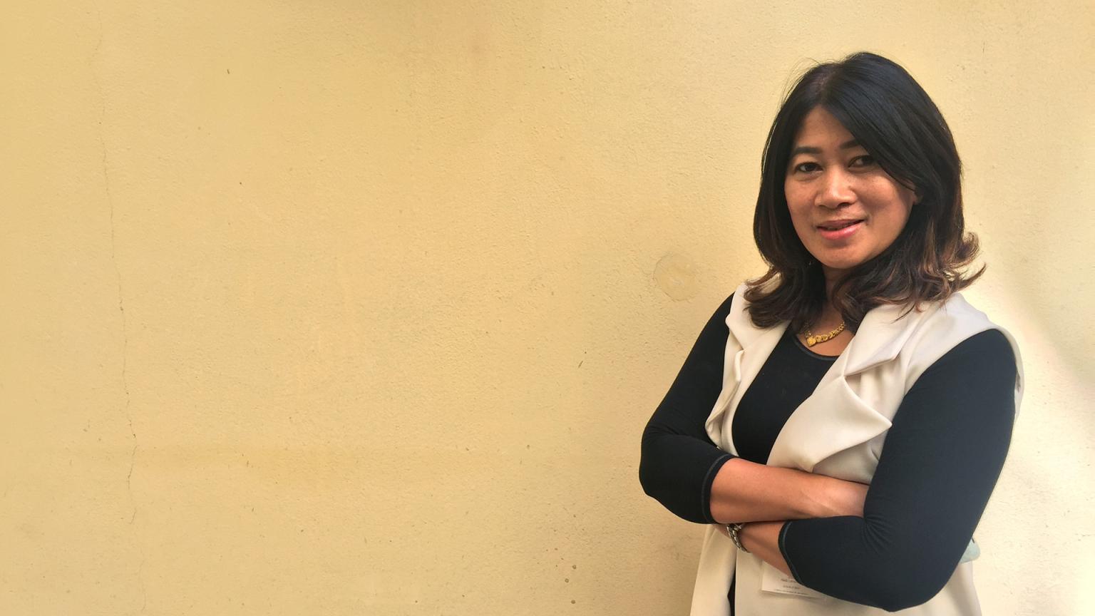 Bild på en thailänsk kvinna med armarna i kors, Apantree Charoensak, mot gul bakgrund