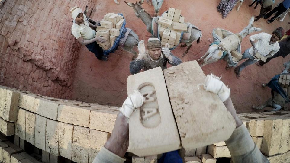 En bild på byggarbetare som lastar tegelstenar