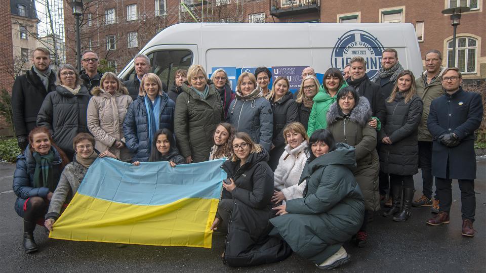 En bild på svenska och ukrainska fackligt engagerade framför en skåpbil